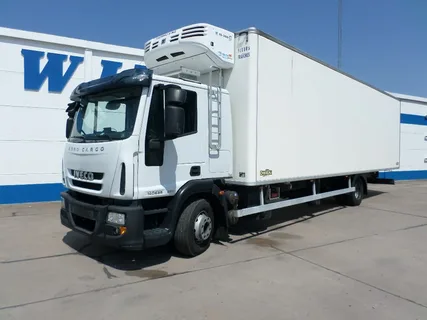 Modern white IVECO freezer truck rental vehicle parked outside a logistics facility in the UAE, showcasing insulated body and rooftop refrigeration unit for temperature-controlled deliveries